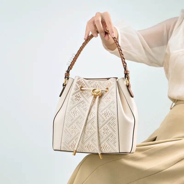 anj-pattern-embroidered-leather-convertible-backpack-tote-model-sitting-knee-handheld anj-pattern-embroidered-leather-convertible-backpack-tote-model-sitting-knee-handheld